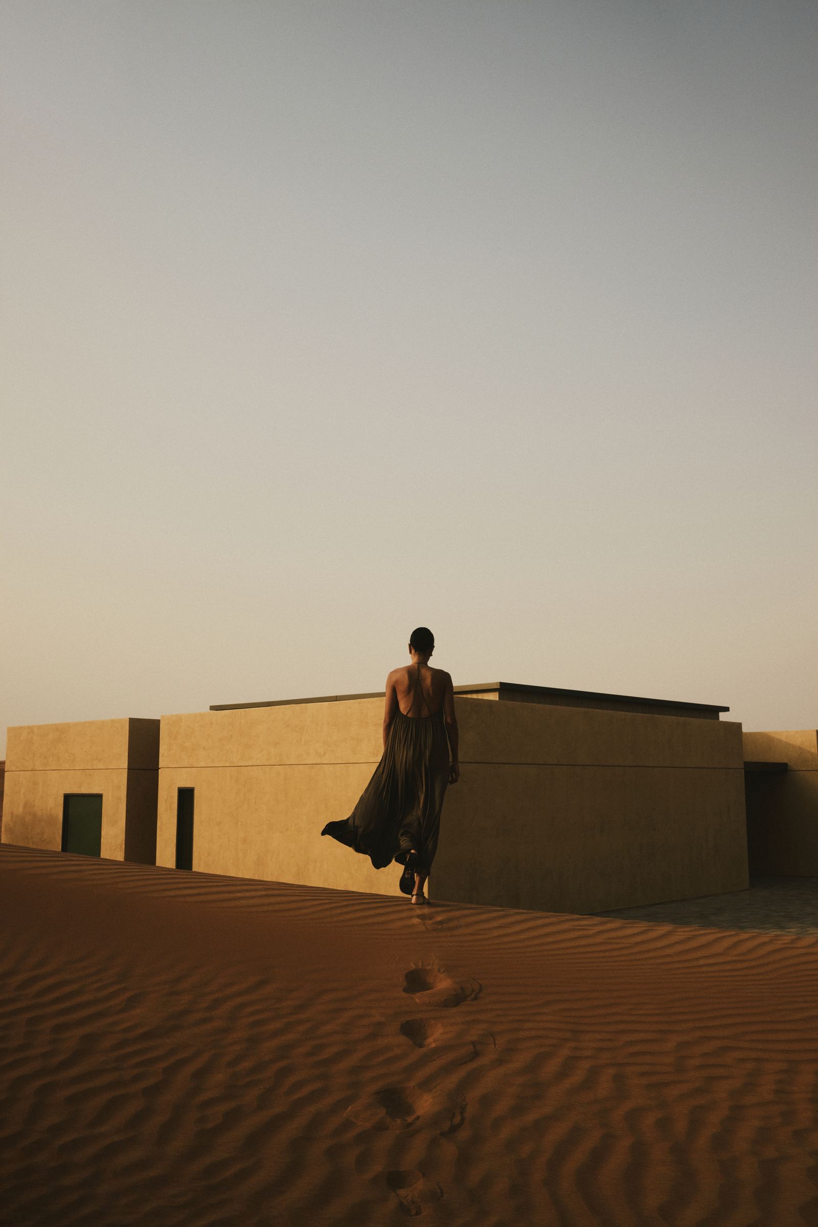 Footprints across the dunes towards a villa